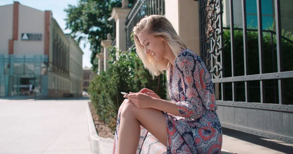 Joven hermosa mujer rubia usando tableta digital en una calle de la ciudad . — Foto de Stock