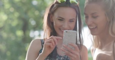 İki genç kız bir şehir parkında istimal hareket eden telefon. 