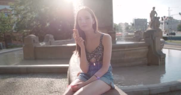 Молодая красивая женщина ест мороженое в солнечный день, на открытом воздухе . — стоковое видео