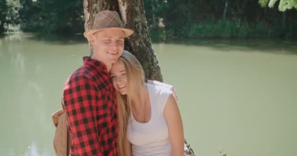 Retrato de una hermosa pareja caucásica pasando tiempo en un bosque durante el día soleado . — Vídeos de Stock