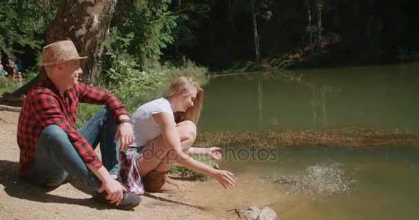 Hermosa pareja caucásica relajándose en un bosque durante el día soleado . — Vídeos de Stock