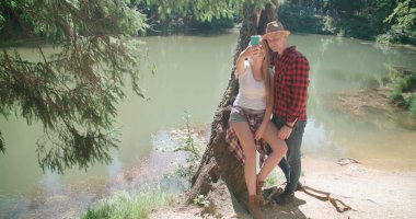 Sevgi dolu bir göl kenarında kendi kendine portre çekici genç Çift. 