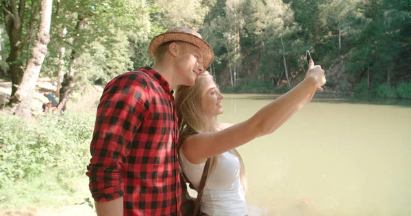 Sevgi dolu bir göl kenarında kendi kendine portre çekici genç Çift. 