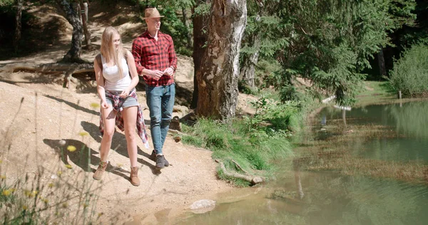 Güzel çift rahatlatıcı bir ormandaki güneşli gün boyunca. 