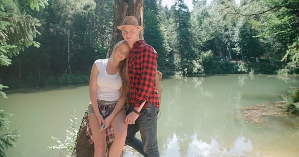 Portrait of beautiful caucasian couple spending time in a forest during sunny day. — Stock Photo, Image