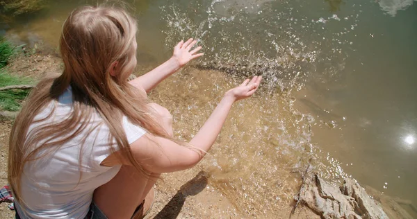 Genç kadın göl eline daldırma. 