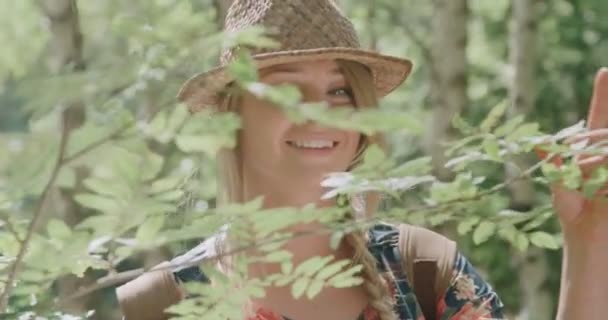 Porträt einer schönen kaukasischen Frau im Wald mit Hut und Rucksack. — Stockvideo