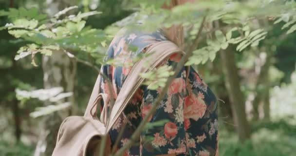 Πορτρέτο του όμορφη γυναίκα Καυκάσιος μέσα σε ένα δάσος φορώντας καπέλο και σακίδιο. — Αρχείο Βίντεο