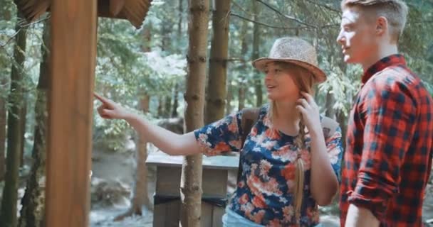 Beautiful caucasian couple hiking in a forest during sunny day. — Stock Video