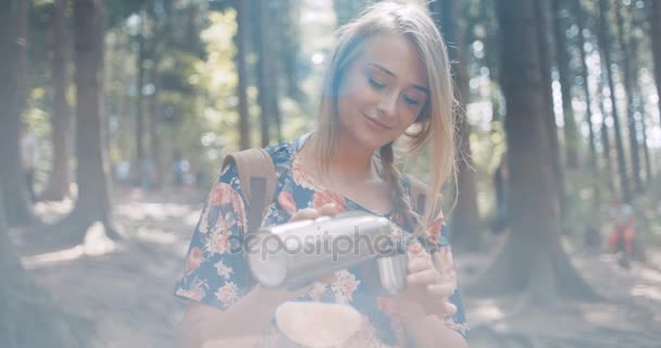Schöne blonde Mädchen gießt Tee aus Thermoskanne. — Stockvideo