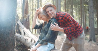 Gülümseyen arkadaşlar ormanda kamera bakıyor.