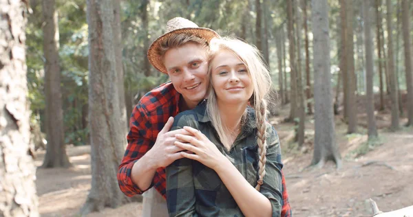 Gülümseyen arkadaşlar ormanda kamera bakıyor.