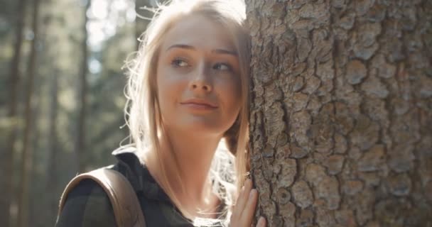 Porträt einer schönen kaukasischen Frau, die an einem Baum posiert. — Stockvideo