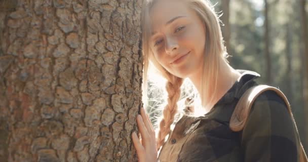 Porträt einer schönen kaukasischen Frau, die an einem Baum posiert. — Stockvideo
