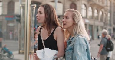 Bir vitrin giysilerle bakarak iki güzel kız. 