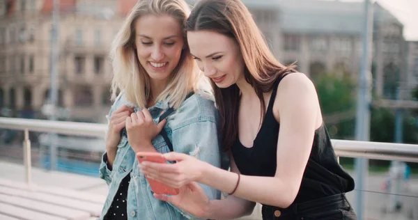 Hermosas mujeres jóvenes viendo fotos en un teléfono . —  Fotos de Stock