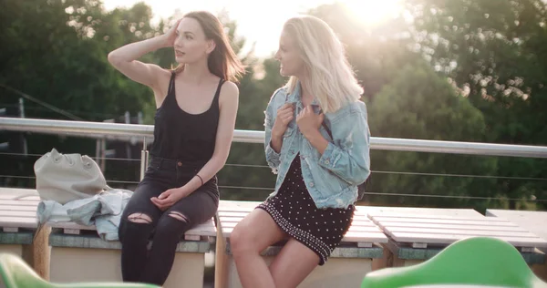 Dos chicas alegres discutiendo las últimas noticias de chismes en una ciudad . — Foto de Stock