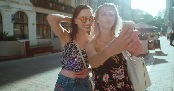 İki genç güzel kız selfie bir şehir sokak alarak. 