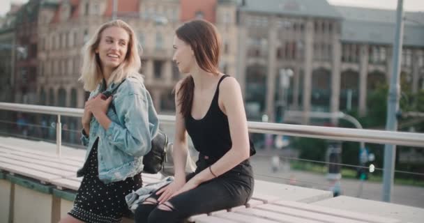 Duas meninas alegres discutindo as últimas notícias fofocas em uma cidade . — Vídeo de Stock