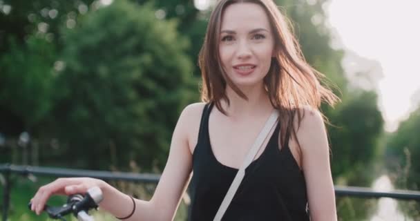 Portrait of ceria tersenyum wanita muda dengan sepeda di jalan kota . — Stok Video
