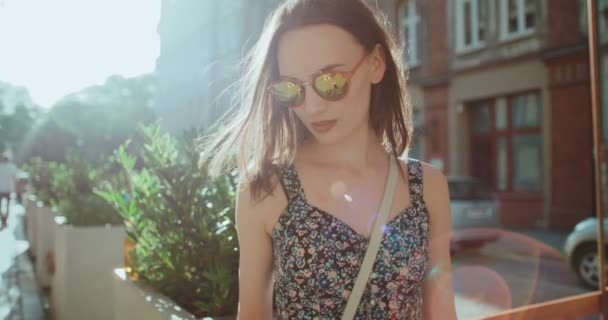 Gyönyörű fiatal nő beszél telefonon napsütéses napon. — Stock videók