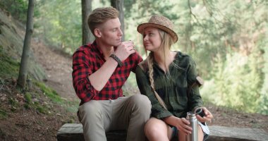 Gülümseyen çift ormanda vakit.