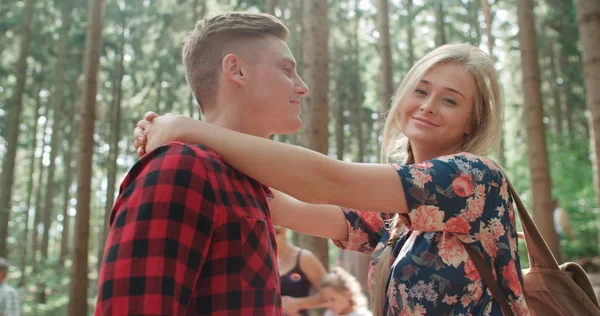 Retrato de una hermosa pareja caucásica pasando tiempo en un bosque durante el día soleado . — Foto de Stock