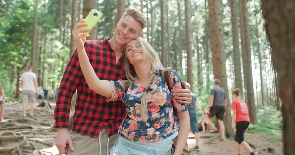Amar joven pareja caucásica tomando autorretrato en un bosque . —  Fotos de Stock