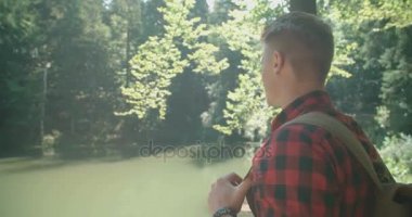 Yakışıklı beyaz adam bir ormanda yürüyor. 