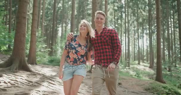 Porträtt av vackra kaukasiska par tillbringa tid i en skog under solig dag. — Stockvideo