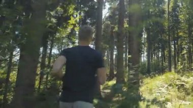 Yakışıklı adam bir ormanda bulunan ve güneşli gün boyunca çalıştıran. 