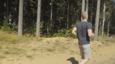 Yakışıklı adam bir ormanda bulunan ve güneşli gün boyunca çalıştıran. 