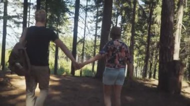 Vakit bir ormanda güneşli gün boyunca güzel çift arka görünümü. 