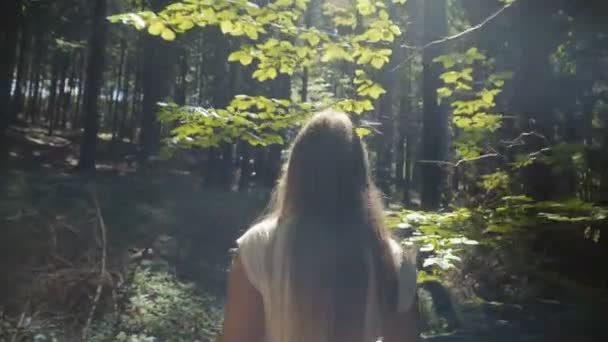 Bakifrån av kaukasisk kvinna promenader i skogen. — Stockvideo