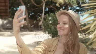 Selfie fotoğraf onu tatil sırasında yapma şapkalı güzel bir kadın. Telefon, açık havada kullanan genç kadın.