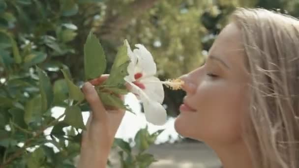 咲く花に近い若い美しい女性 花が咲き乱れる春の女性 エコの美容と健康の概念 — ストック動画