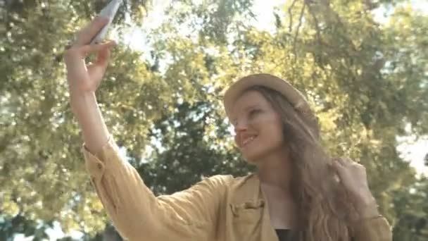 帽子は 彼女の休暇中に Selfie の写真を作るには美人 携帯電話を屋外で使う若い女性 — ストック動画