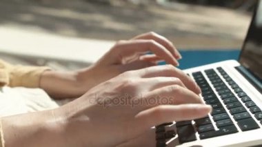 Tipik bir dizüstü bilgisayar üzerinde açık havada kadının el kapatın. Yüzme havuzunda oturuyor dizüstü bilgisayar ile çalışan kadın. Klavyede yazarak eller.