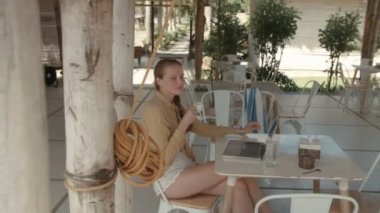 Dizüstü bilgisayarda çalışırken içme espresso restoranda güzel bir kadın. Kadın kahve brak lüks resort tatil bilgisayarla çalışırken sahip.