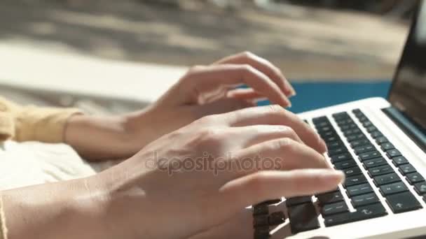 屋外のラップトップ コンピューターで入力する女性の手のクローズ アップ 女性スイミング プールに座ってラップトップ コンピューターで作業します 女性の手をキーボードで入力します — ストック動画