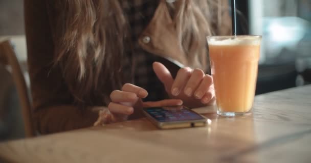 レストランでスマート フォンを使用して女性の手のクローズ アップ 若い女性持株電話 — ストック動画