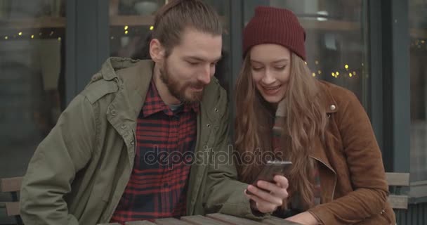 Piękna Para Patrząc Smartphone Siedząc Restauracji Zewnątrz — Wideo stockowe