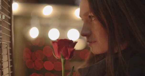 美丽的黑发女孩站立与红色玫瑰在城市 — 图库视频影像