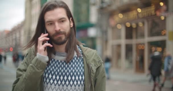 都市屋外電話呼び出しを行う長い髪の流行に敏感な男性の肖像画間近します — ストック動画
