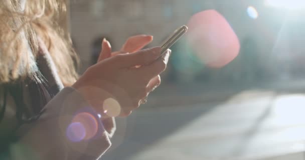 携帯電話を屋外で使う若い女性の手のクローズ アップ — ストック動画