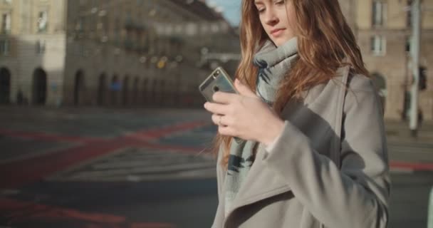 魅力的なブルネット若い女性通り街で歩きながら電話で話しています — ストック動画