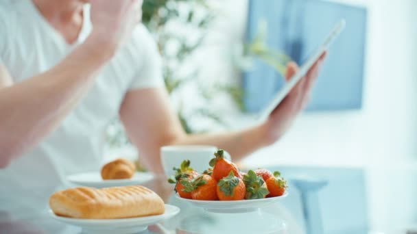 Genç Adam Mutfak Masasında Kahvaltı Yaparken Dijital Tablet Kullanma — Stok video