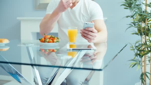 Hombre Joven Guapo Usando Teléfono Durante Desayuno — Vídeos de Stock