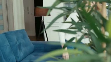 Evde kanepede otururken tablet bilgisayar kullanan genç kadın.