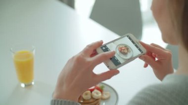 Genç kadın kahvaltısını sosyal medya için fotoğrafı yapma.